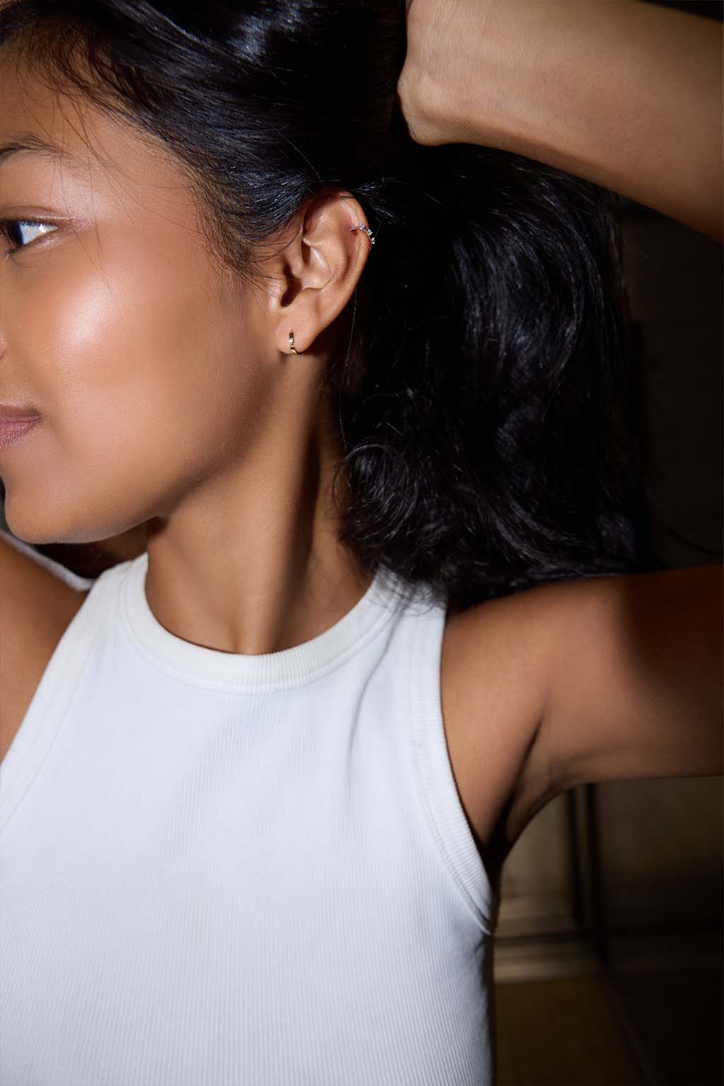 Model wearing the Gold Dash Line Earring in 18k gold. A minimal hoop with a narrow line detail, sitting close to the ear.