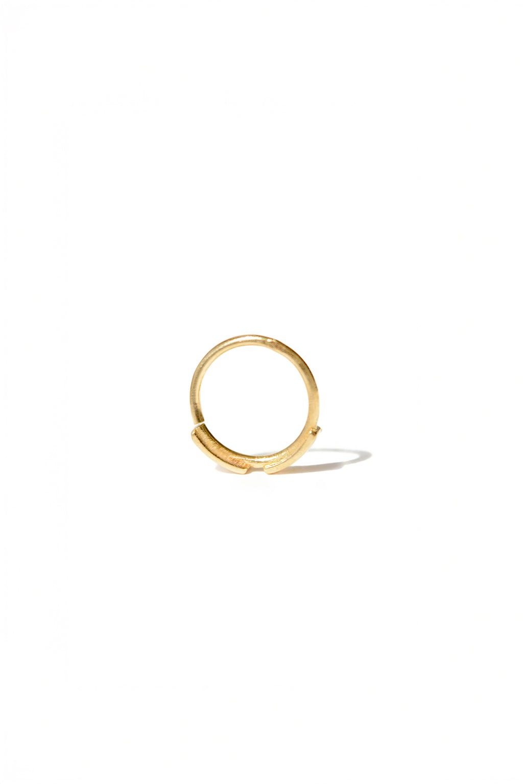 Gold dash line earring in 18k gold, small circular bangle with subtle narrowing in its shape. Designed by Sansoeurs.