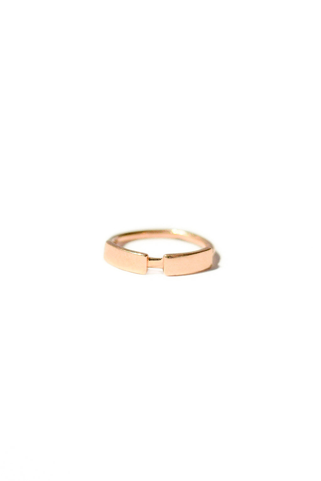 Gold dash line earring in 18k rose gold, small circular bangle with subtle narrowing in its shape. Designed by Sansoeurs.