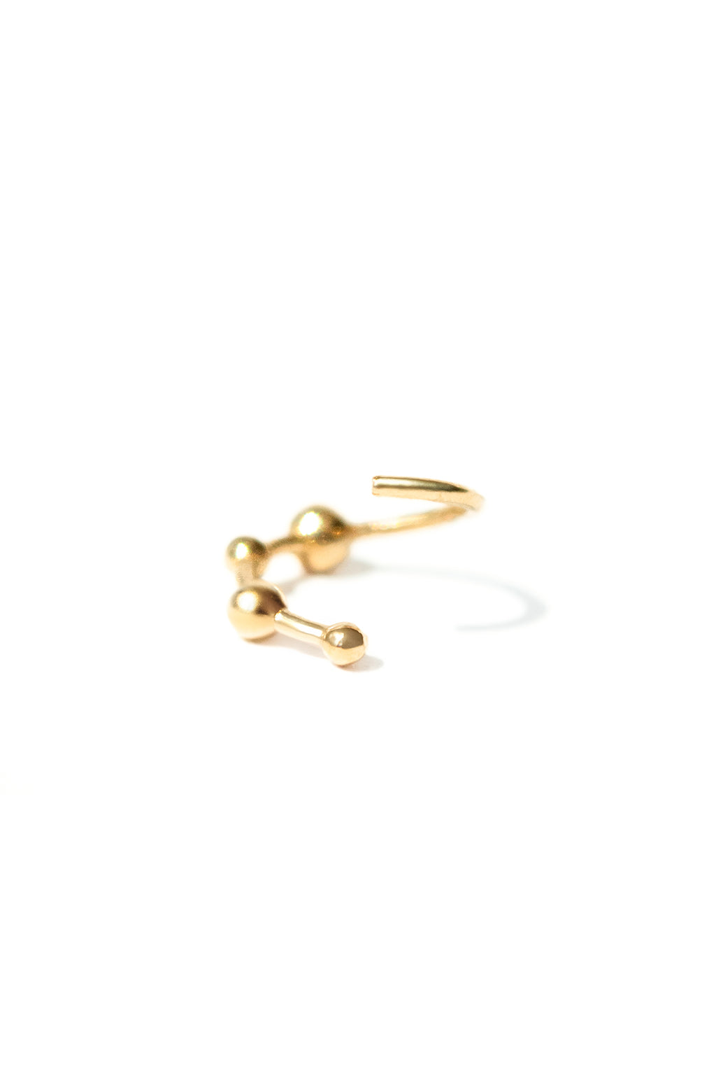 18k yellow gold mini bangle earring with four sculpted spheres, opened, seen from the front on a white background