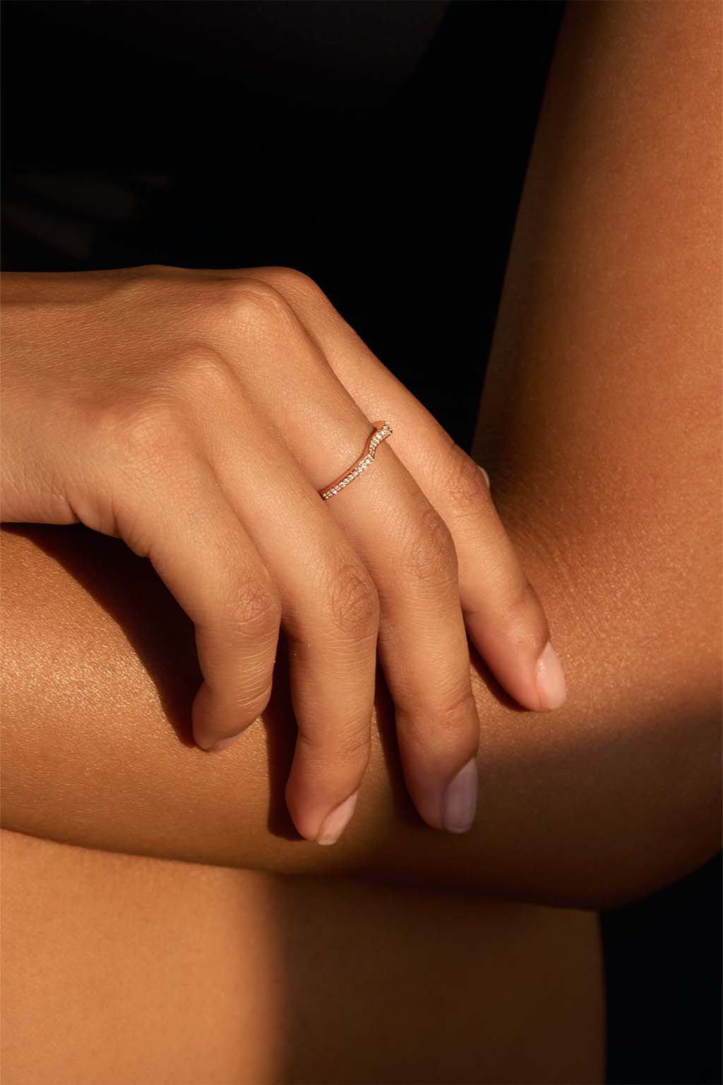 Model wearing the Irregular 18k gold ring with diamonds. Its organic silhouette follows the contour of the finger in a soft, fluid gesture.