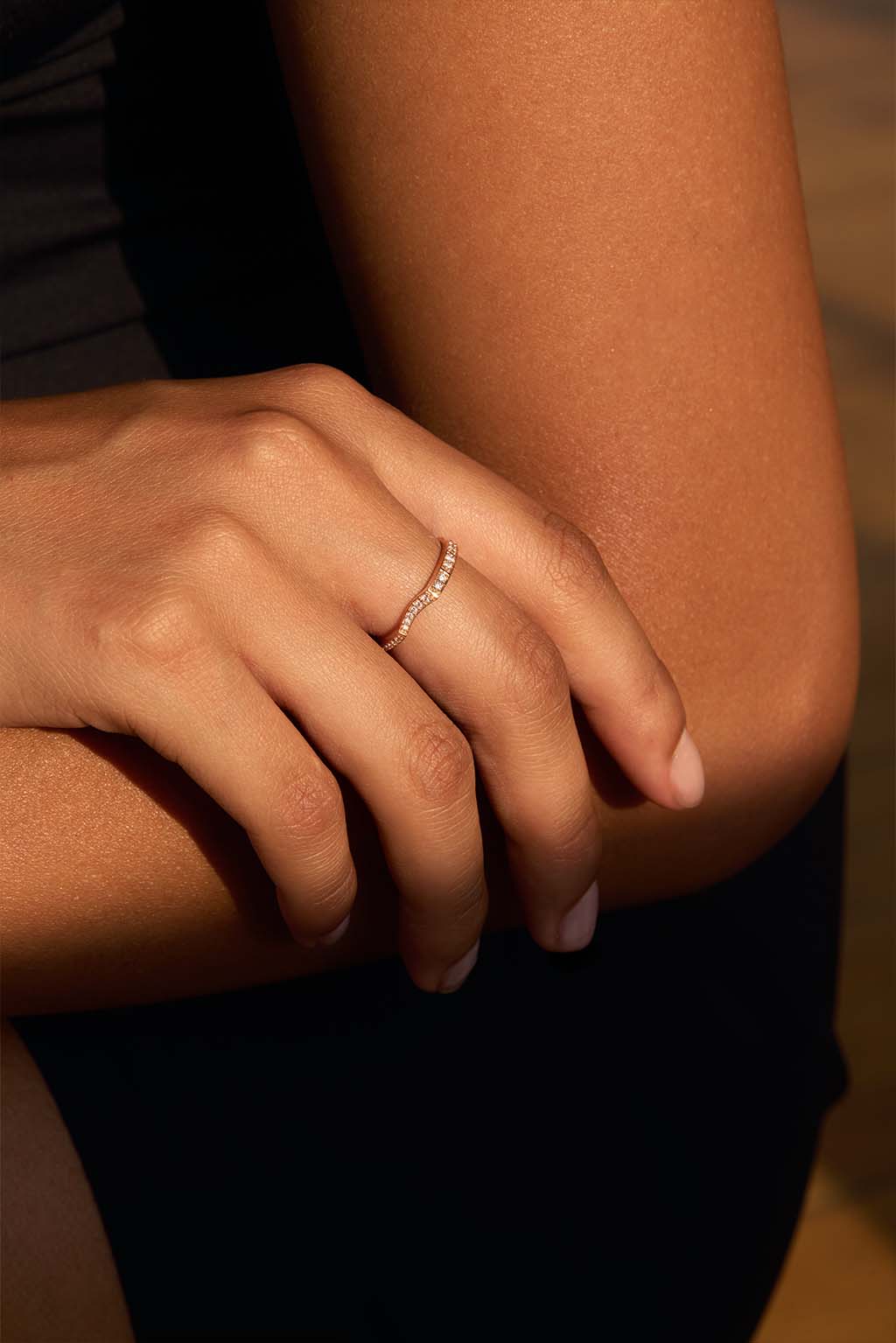 Model wearing the Irregular 18k gold ring with diamonds. Its organic silhouette follows the contour of the finger in a soft, fluid gesture.