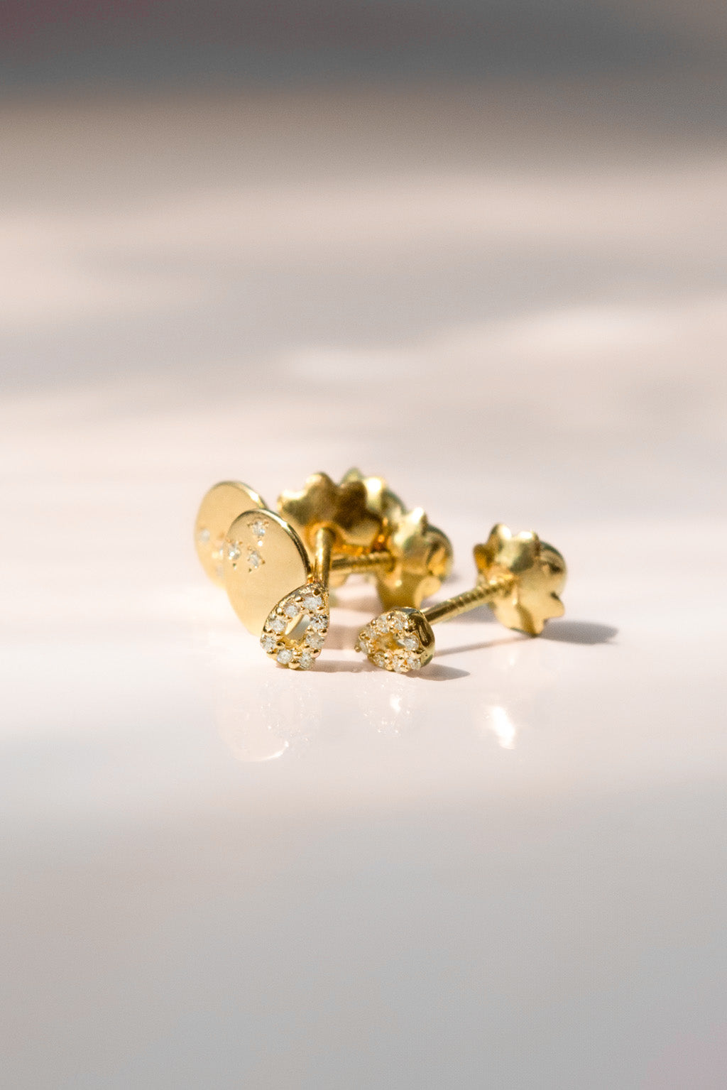 Bubbles and Dots gold and diamonds baby earrings by Sansoeurs, drop-shaped studs with diamonds