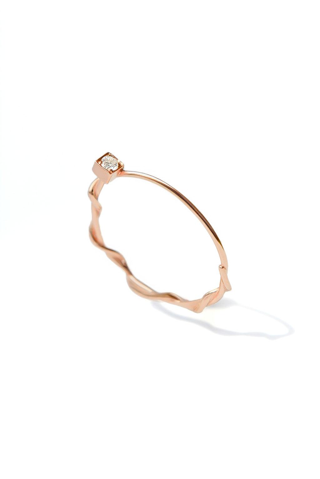Small Miki 18k gold ring with a 2 mm diamond, featuring a double round band intertwined in the middle and a simple upper band, photographed on white background