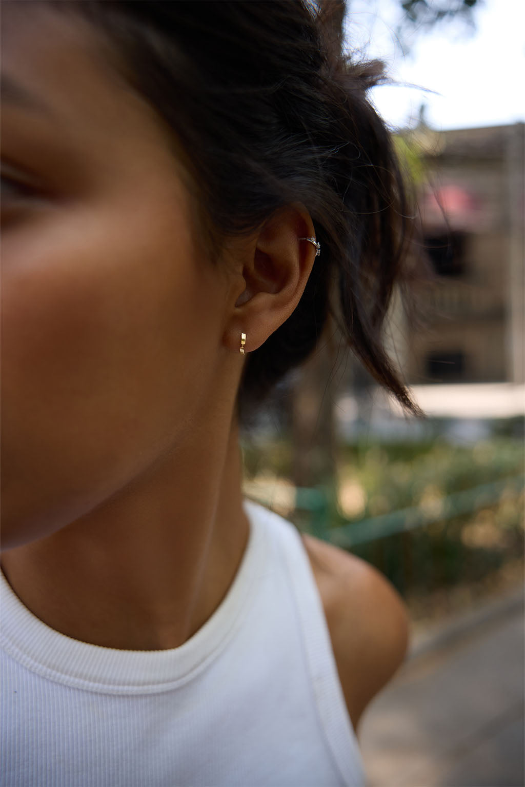 Model wearing the Gold Dash Line Earring in 18k gold. A minimal hoop with a narrow line detail, sitting close to the ear.