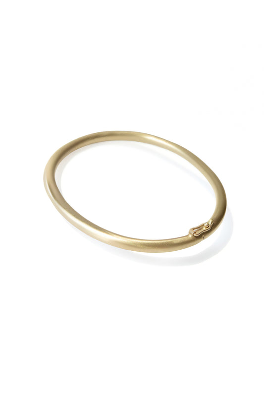 Gold oval bracelet with matte finish on white background