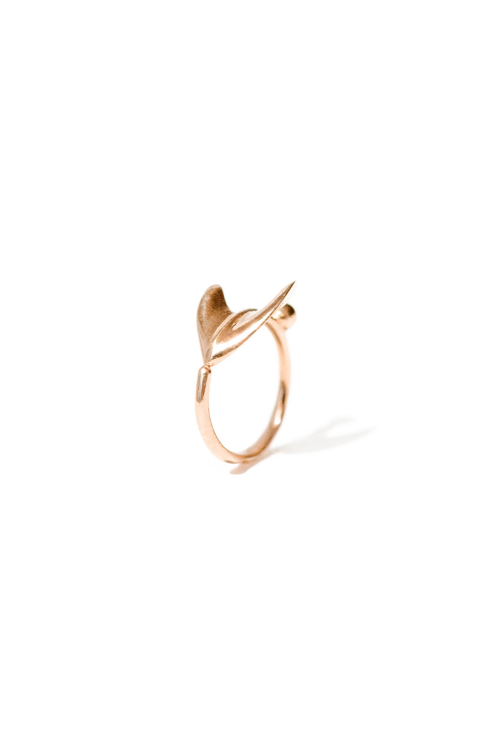 Close-up of the Floral Mini Bangle in 18k gold by Sansoeurs, featuring an arrow-like organic form and small sphere