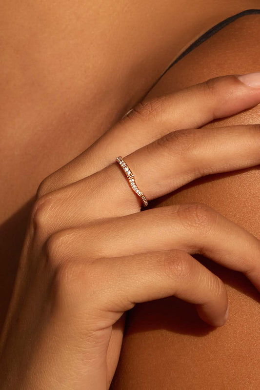 Model wearing the Irregular 18k gold ring with diamonds. Its organic silhouette follows the contour of the finger in a soft, fluid gesture.