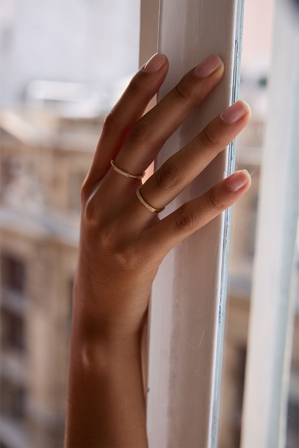 Model wearing the Moi-Moi ring in 18k gold. Two mirrored diamond-set sections trace the finger with a soft repetition that emphasizes the sense of connection.