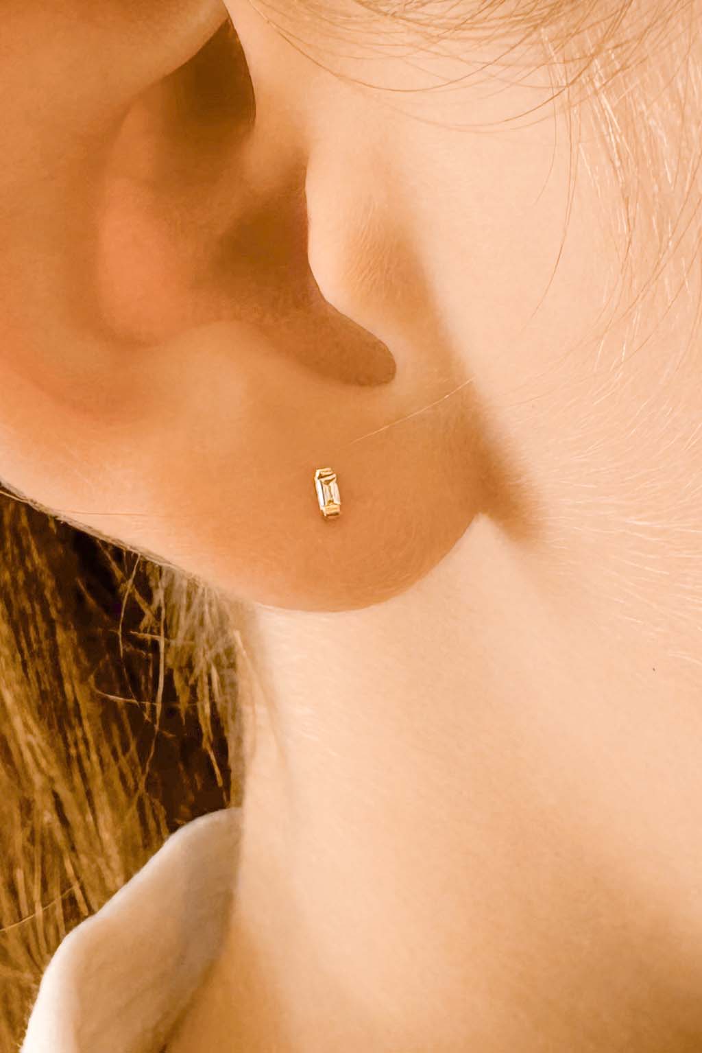 Baguette gold and diamond baby earrings by Sansoeurs, diamond set between two small gold plates