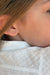 Blond child wearing a single Baby Box earring in 18k yellow gold with diamonds by Sansoeurs, visible on one ear.