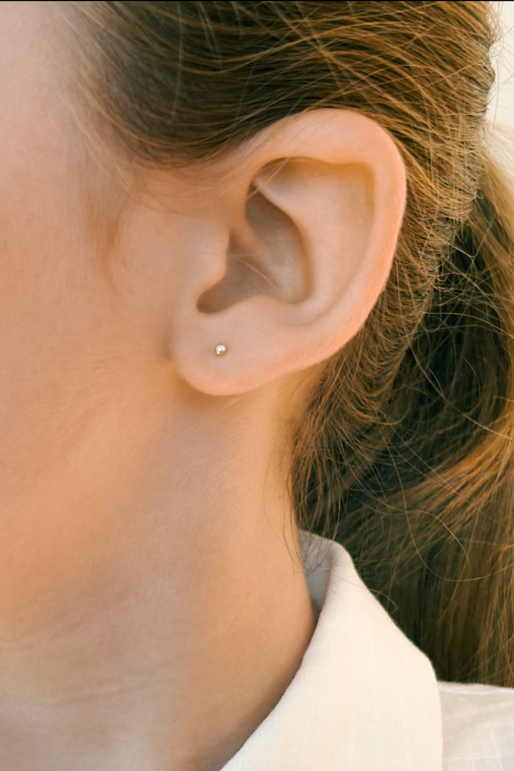 Eye gold and diamond baby earrings by Sansoeurs, diamond set in circular gold bezel