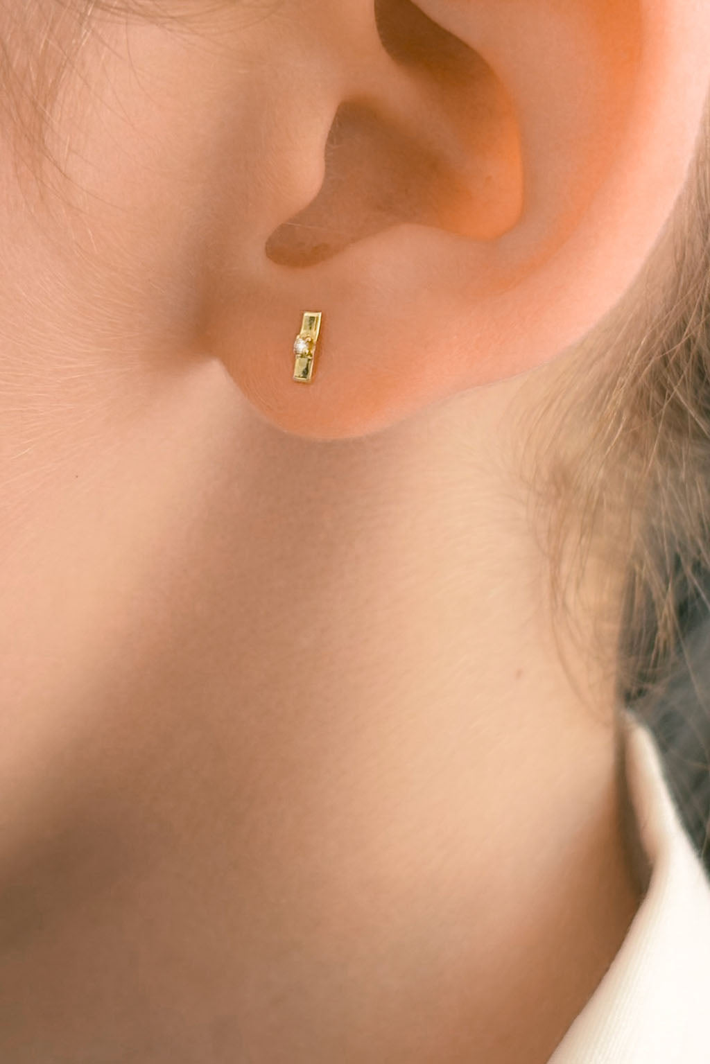 Plaque Tag gold and diamond baby earrings by Sansoeurs, tiny rectangular gold studs with a central diamond