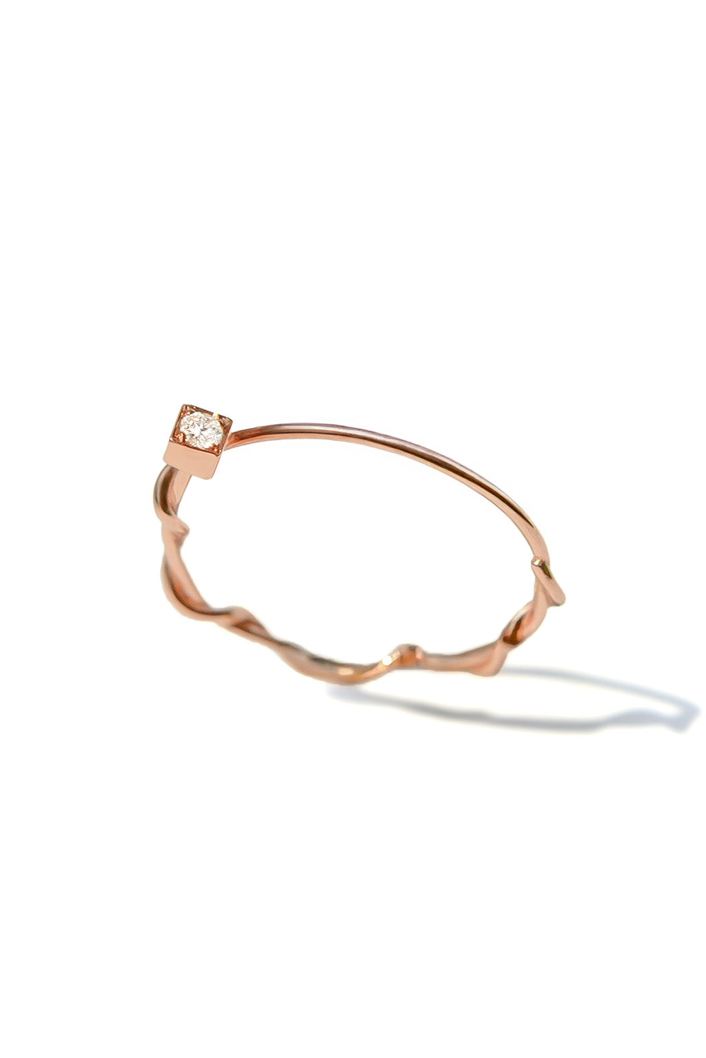 Small Miki 18k gold ring with a 2 mm diamond, featuring a double round band intertwined in the middle and a simple upper band, photographed on white background